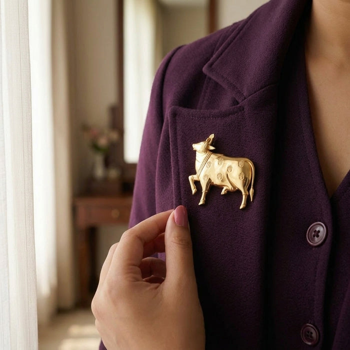 925 silver pichwai cow gold plated brooch on a purple coat with a blurred indoor background